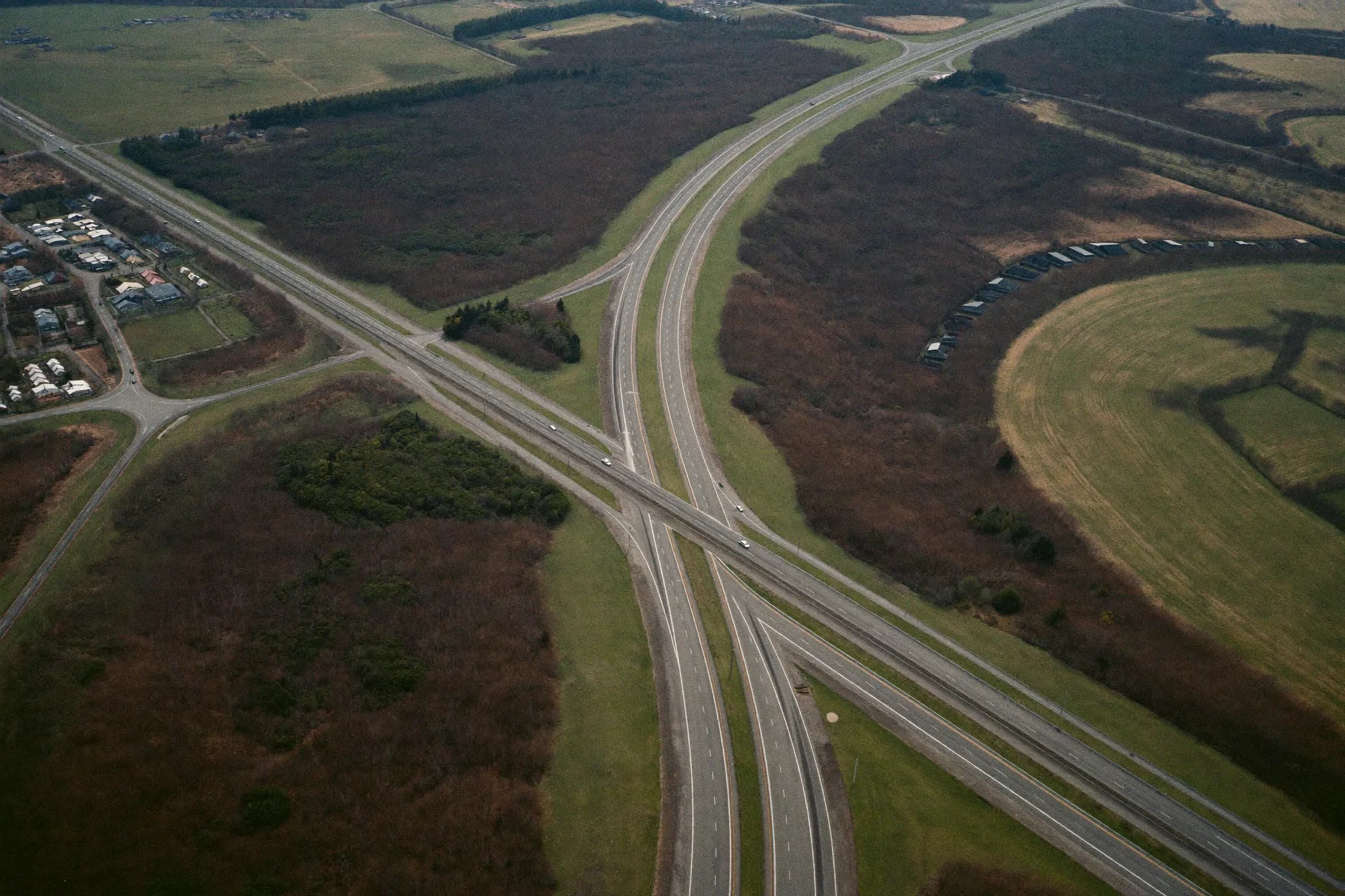 A highway interchange crossing farmland from above