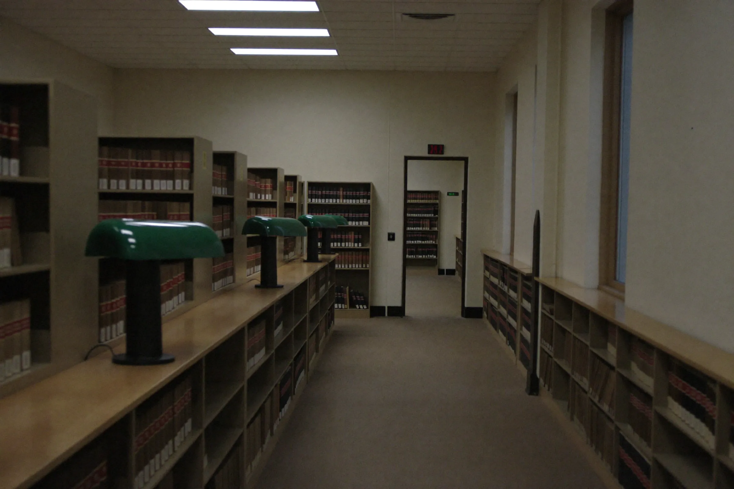 A quiet law library corridor with green lamps
