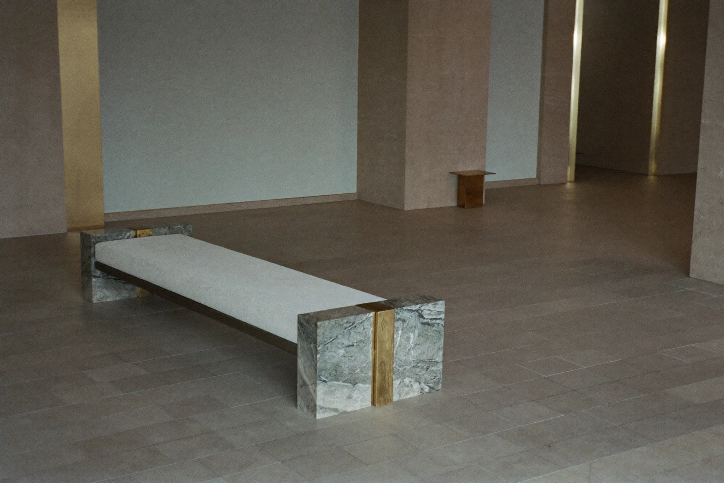 A stone-floored reception lobby with a single bench